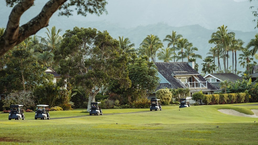 Golf carts spread across a green resort fairway near palm trees.