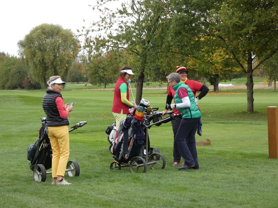 Four women gathered around golf bags on a course