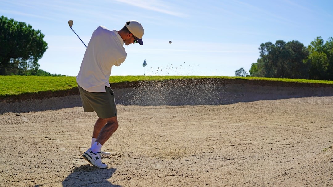 A man is playing golf on a sunny day